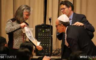Stephen Wise Temple Executive Director Sharon Spira-Cushnir and Senior Rabbi Yoshi Zweiback bestow a gift of gratitude upon outgoing Board president Steve Bram on June 16, 2023. (Photo by Raz Husany)